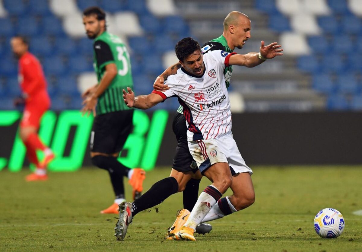 Vlad Chiriches of Sassuolo competes for the ball with Giovanni Simeone of Cagliari