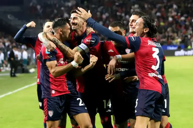 Cagliari players celebrate scoring against Milan